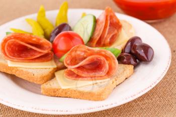 Sandwiches on plate on beige mat background.