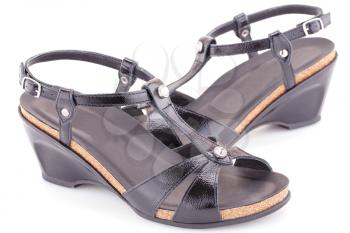 Black shiny sandals isolated on white background.