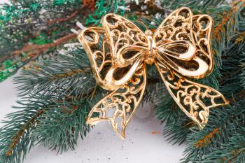 Christmas decoration with yellow ribbon and fir-tree branch.