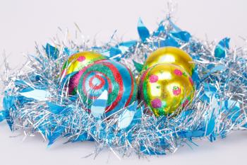 Christmas balls and blue garland on gray background.