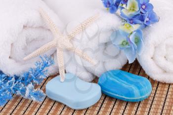 White towels with blue flowers and soaps, starfish closeup picture.
