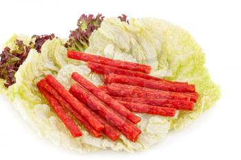 Small sausages on lettuce isolated on white background.
