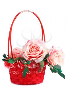 Pink fabric roses in wicker basket isolated on white background.