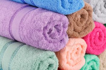 Colorful rolled towels stack closeup picture.