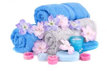 Spa set with towels, candles, soaps and flowers isolated on white background.