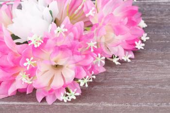 Colorful fabric flowers on wooden background, closeup picture.