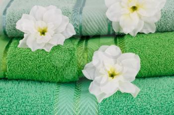Folded towels and flowers closeup picture.