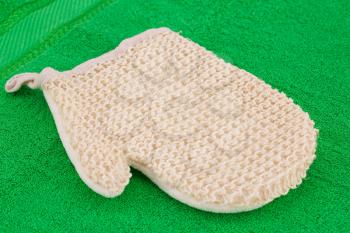 Glove massager on green towel, closeup picture.
