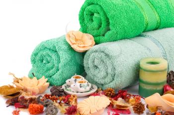 Spa set with towels, candles, flowers and various formed soaps closeup picture.