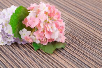 Colorful artificial flowers on cloth background, closeup picture.