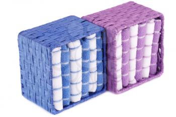 Pink, blue and white folded towels in boxes isolated on white background.