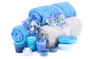 Spa set with towels, candles, flowers and various soaps isolated on white background.