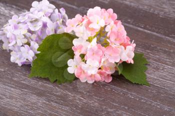 Pink fabric flowers on wooden background, closeup picture.