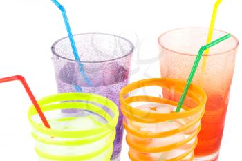Plastic glasses with water, ice cubes and straws on white background.