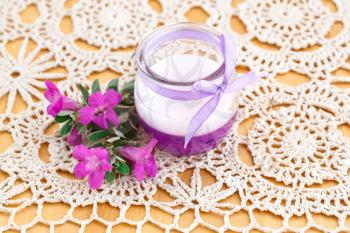 Beautiful candle and pink flowers on cloth background.