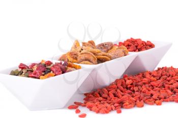 Dried fruits, berries and seeds in bowl on white background. 