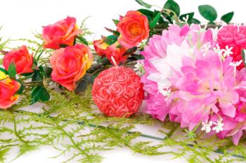 Colorful flowers and candles on white background.