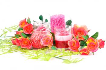 Colorful roses and candles on white background.