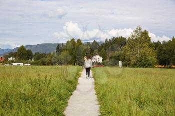 Young woman walking in Heddal village on hills in Norway.