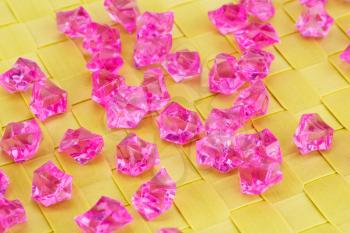 Pink plastic stones on bamboo background.