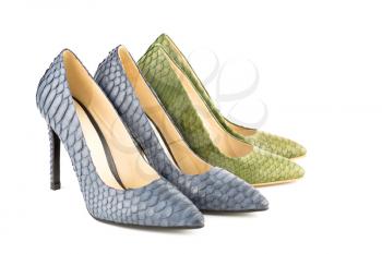 Two pairs of stylish high heels python leather shoes isolated on white background.