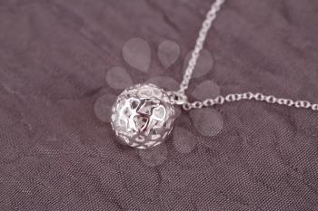 Silver necklace on fabric background.