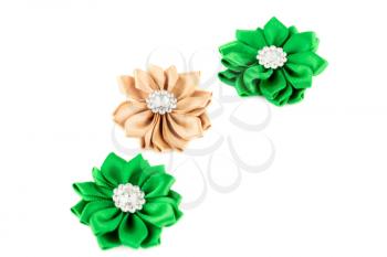 Green and beige fabric flowers with stones isolated on white background.