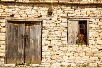 Old wooden door with chain and window in Limnatis village, Cyprus.