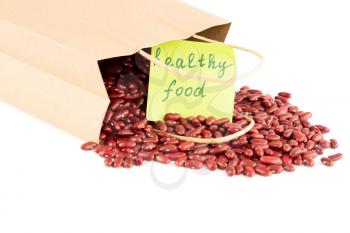 Red kidney beans in the paper bag with the notice healthy food on a white background.