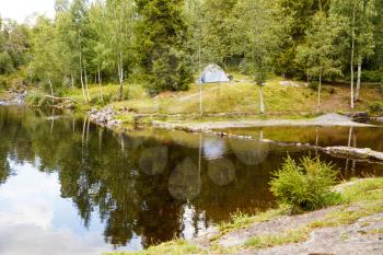 Landscape with forest, pond and tent in Norway.