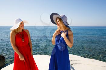 Blond women in the red and blue dresses at the beach in Cyprus.