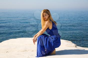 Pretty blond woman in the blue dress at the beach in Cyprus.