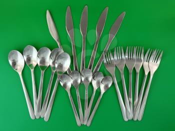 Table serving-knife,plate,fork and   on  green background.