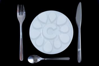 Table serving-knife,plate,fork on  various colour background.