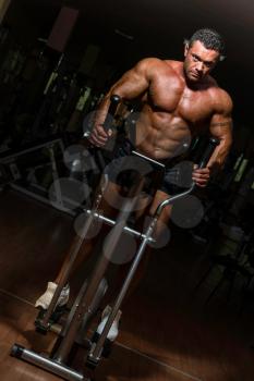 male bodybuilder using the elliptical machine