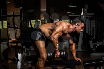 male bodybuilder doing heavy weight exercise for back
