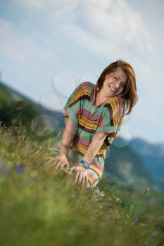 beautiful woman in dress sitting on the grass