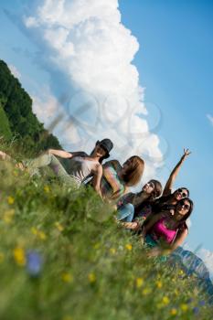 group of girls sitting on grass and having fun