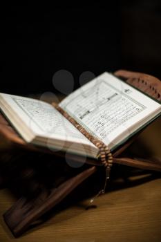 pages of holy koran and rosary at the book