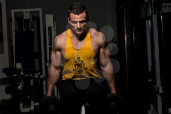 fitness trainer posing with dumbbells