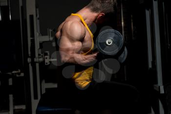 young man doing heavy weight exercise for biceps