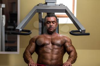 bodybuilder resting after doing heavy weight exercise