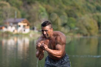 Attractive Man Standing In River And Enjoys The Nature