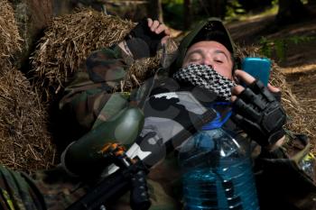 Paintball player resting and looking at the phone