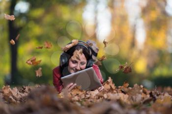 Girl Listening To Music On Autumn Leaves