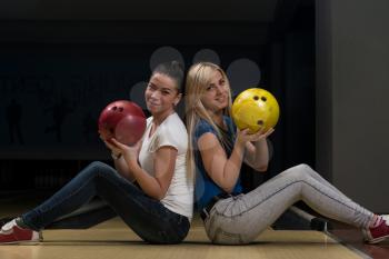 Cheerful Young Couple Holding Bowling Ball