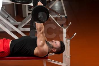 Muscular Man Exercising Triceps With Barbell