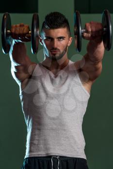 Muscular Men Exercising Shoulder With Dumbbells