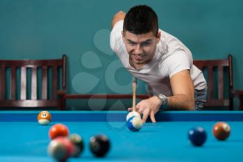 Young Men Lining To Hit Ball On Pool Table