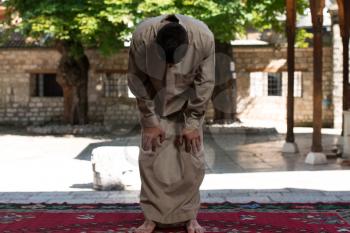 Young Muslim Man Making Traditional Prayer To God While Wearing A Traditional Cap Dishdasha